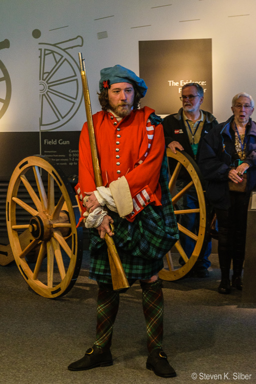 Scotsman in the Visitors' Center describes armaments and conditions at the  time of  Culloden battle. (1/30 sec at f / 5.6,  ISO 800,  55 mm, 18.0-55.0 mm f/3.5-5.6 ) May 09, 2017